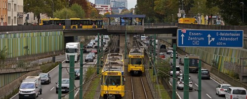 Lots of traffic on the A 40 motorway on four lanes and two subways on two lanes and a bus on the