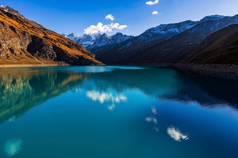 The turquoise Lac de Moiry reservoir, behind the peaks of the Grand Cornier, Tete Blanche and