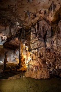 Stalactites and stalagmites, rock formations in a stalactite cave with water basin, Grotta del