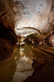 Stalactites and stalagmites, reflection in a small underground lake, rock formations in a