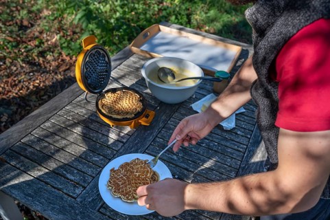 Preparation of waffles with a waffle iron on an outdoor garden table, Othenstorf,