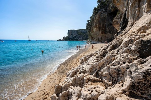 Sandy beach beach and steep cliffs at Cala Luna, Golfo di Orosei, Baunei, Sardinia, Italy