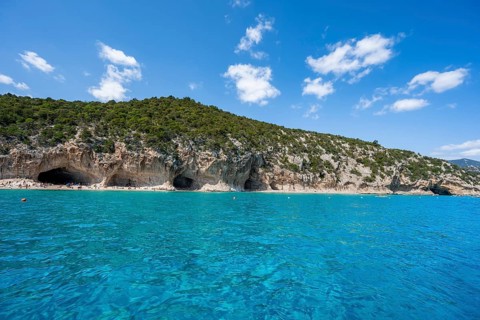 Clear blue water and picturesque rocky coast, Cala Luna cliffs and beach, Golfo di Orosei, Baunei,