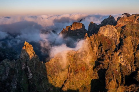 Aerial view, sunrise at Pico do Arieiro, clouds of fog sweeping over mountain peaks, Madeira,