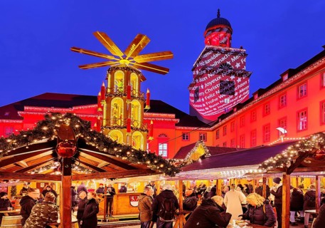The Christmas market with the mulled wine pyramid and the illuminated town hall in the evening,