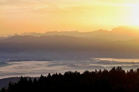 View from Horben of Lake Zug with the city of Cham and Zug covered in fog, behind it the