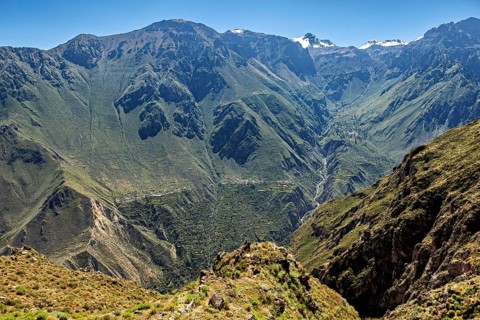 Impressive mountain landscape with deep valleys and snow-capped peaks in the distance, The
