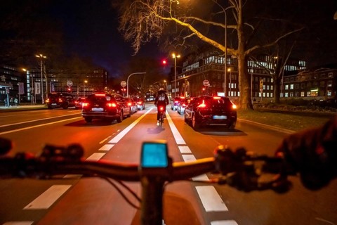 Cycling in the city, in the dark, in the evening, cycling on a bike lane, marked in red,