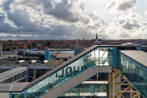 Ferry terminal, harbor with cityscape, St. Nicholas Church, dramatic cloudy sky, sunbeams, Rønne,