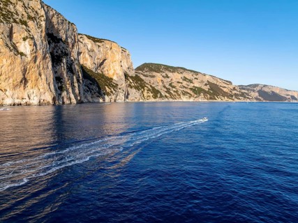 Motorboat rides on picturesque rocky coast ImmorgenLicht, cliffs, Golfo di Orosei, Baunei,