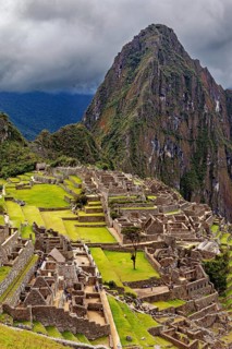 Historic ruins and a dramatic mountain against a cloudy sky, The ruins of the Inca city of Machu