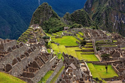 Ancient stone ruins and green terraces against a mountain backdrop, The ruins of the Inca city of
