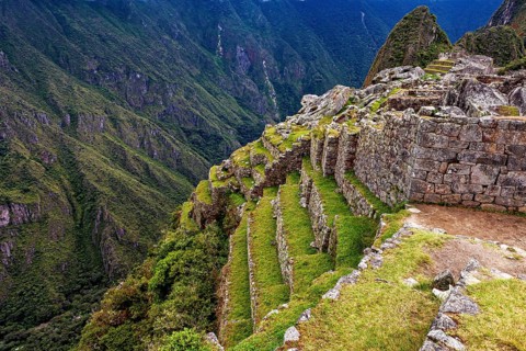 Machu Picchu terraces along a steep mountain flank in lush nature, The ruins of the Inca city of