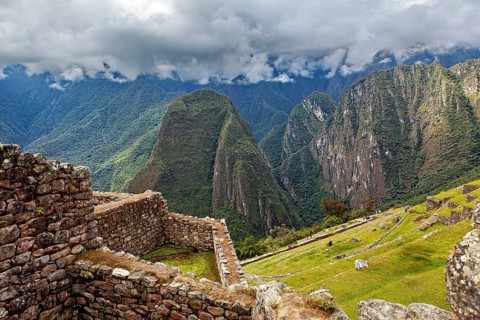 Stone ruins with a view of an imposing mountain landscape under clouds, The ruins of the Inca city