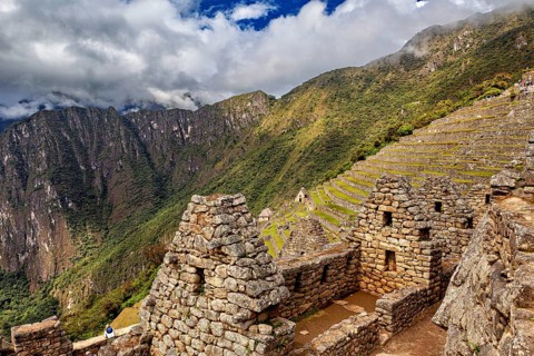 Old stone buildings with terraces in a mountainous landscape under clouds, The ruins of the Inca