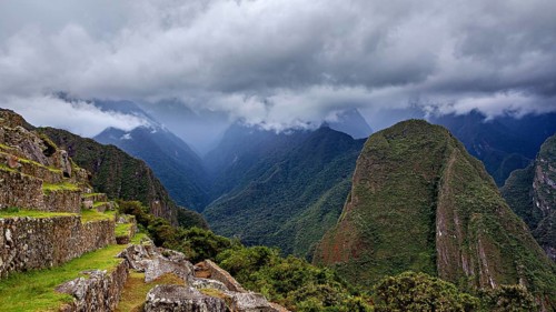 Dramatic mountain landscape with clouds and lush greenery interspersed with fog, The ruins of the