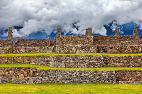 Stone ruins on several levels with mountains and clouds in the background, The ruins of the Inca