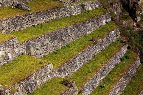 Close-up of hard stone terraces with grassy steps, The ruins of the Inca city of Machu Picchu in