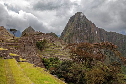 Terraced ruins of Machu Picchu surrounded by mountains and thick fog, The ruins of the Inca city of