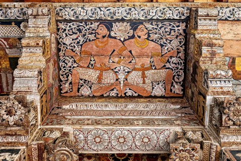 Ornate wall painting with two symmetrical warrior figures in a traditional temple, the decoration