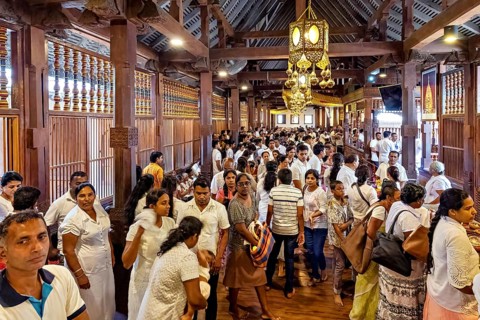 Large crowd in an interior decorated with wooden beams at a meeting, people and pilgrims in the