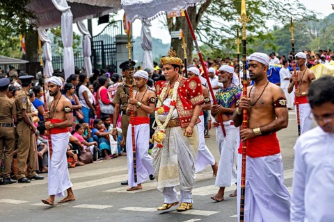 Man in royal dress leads a ceremonial procession at a cultural event, The Perahera Parade in Kandy