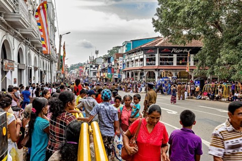 Full of streets with crowds and stalls during a festival, the Perahera Parade in Kandy Sri Lanka
