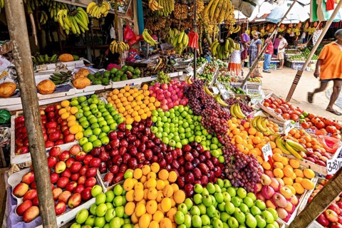 Colourful variety of tropical fruits on a lively market stand, dealers in the market halls of Kandy