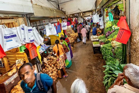 Lively market scene with customers, bags and fresh goods, dealers in the market halls of Kandy Sri