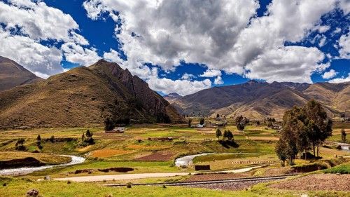 Picturesque landscape with hills, river and lush greenery under a cloudy sky, The landscape in the