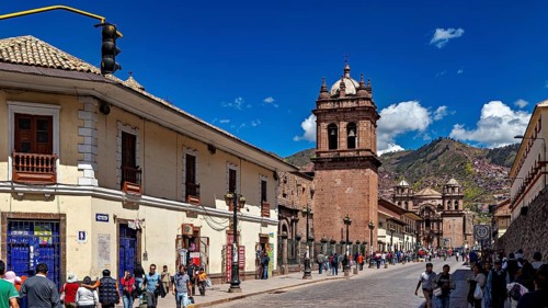 Historic city scene with colonial architecture and busy street life under blue skies, The churches