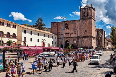 Street scene in a city with a church and people in traditional costumes, traditional parade of