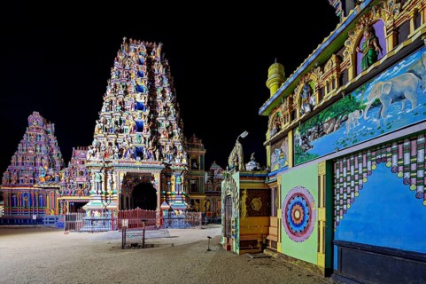 Colourfully illuminated temple complex with complex architecture and wall paintings at night, The