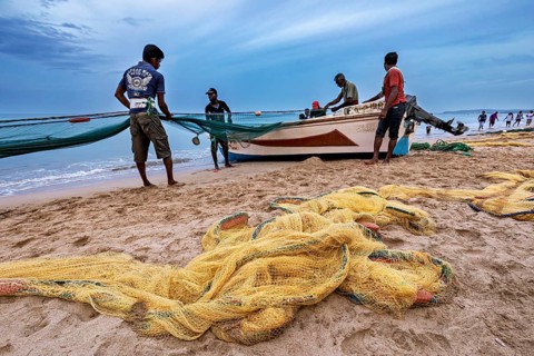 Fishermen on the beach catch up with nets, the sea is calm and the sky is cloudy, Traditional