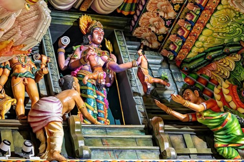 Complex sculpture scene with figures depicting rituals in traditional temple colors, The Sri