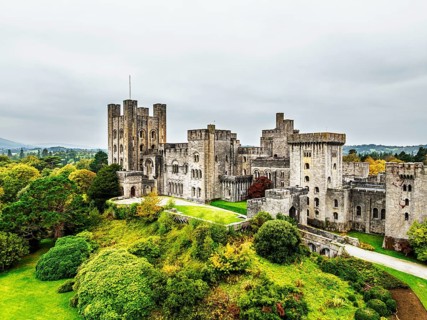 Autumn colours over Penrhyn Castle and Garden from a drone, Llandygai, Bangor, Gwynedd, North