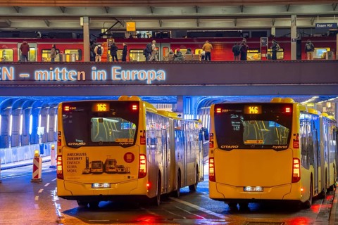 The main train station in Essen, blue illuminated underpass, bus station, am Europaplatz, train on