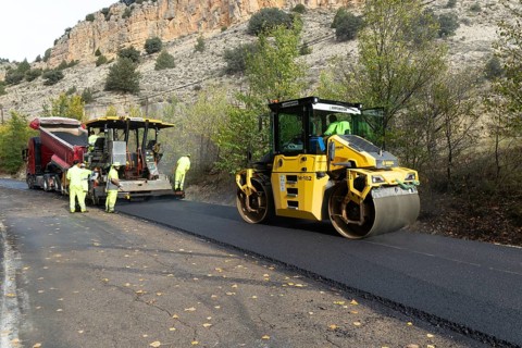 Asphalt road construction team of workers resurfacing tarmac in rural area, near Albarracin, Teruel