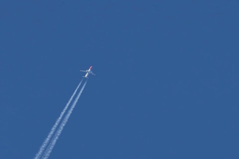 Boeing 737 jet passenger aircraft of Norwegian Air airlines flying in a blue sky with contrails or