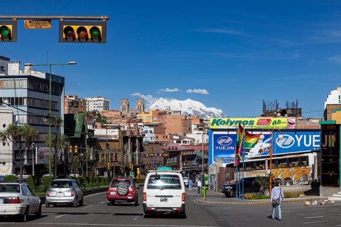 Urban street with traffic and billboards, mountains can be seen in the background, The city of La