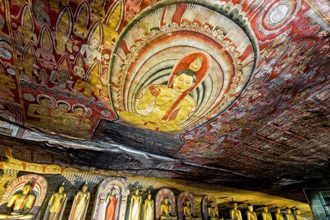 Ceiling painting in a cave with detailed Buddhist representations in strong colors, The cave