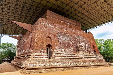 Large antique brick building under a modern roof structure, The temples of Polonnaruwa in Sri Lanka