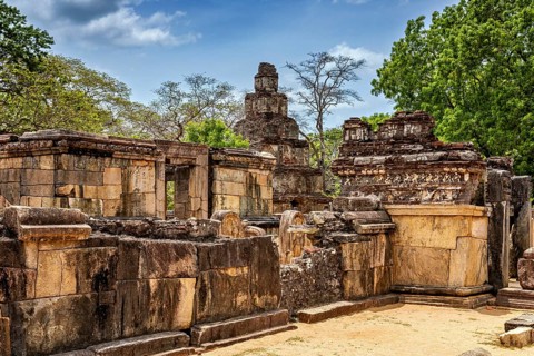 Historic stone ruins with surrounding trees and blue sky as a backdrop, The temples of Polonnaruwa