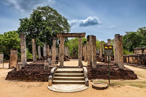 Entrance with ancient columns and sandy soil under a partly cloudy sky, The temples of Polonnaruwa
