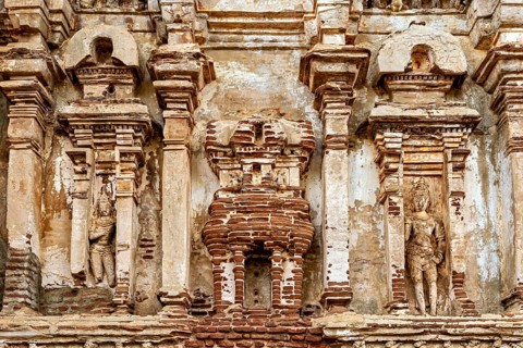 Detailed view of an ancient wall with stone reliefs and weathered surface, The temples of