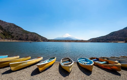Rowing boats on shore, view across the lake to Mt Fuji volcano, Motosu Lake, Yamanashi Prefecture,