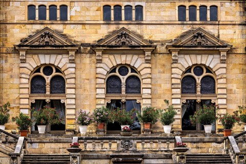 Architectural details with floral arrangements in front of magnificent castle windows, The
