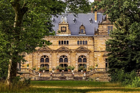 Impressive historic castle surrounded by trees and green lawns, The Hummelshain hunting lodge in
