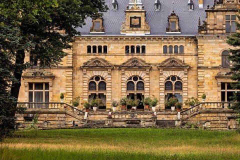 Historic castle façade with decorative windows and a lawn in front of it, The Hummelshain hunting