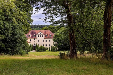 A manor house nestled in trees and meadows, idyllic rural ambiance, The Hummelshain hunting lodge